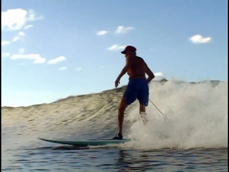 Historical footage of surfer Woody Brown transitioning into a contemporary interview where he reflects on his life and ocean experiences at age 94.