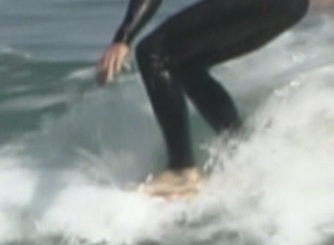 A surfer in a wetsuit maneuvers across the face of an ocean wave, demonstrating balance and control in the water.