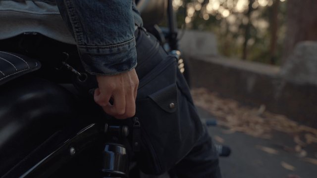 A motorcyclist retrieving documents out of his bag