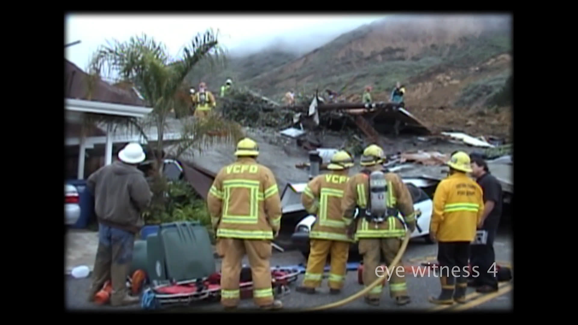 Emergency personnel conduct search and rescue operations in the aftermath of a devastating landslide in La Conchita. Teams navigate debris and damaged structures near the unstable hillside to locate victims.
