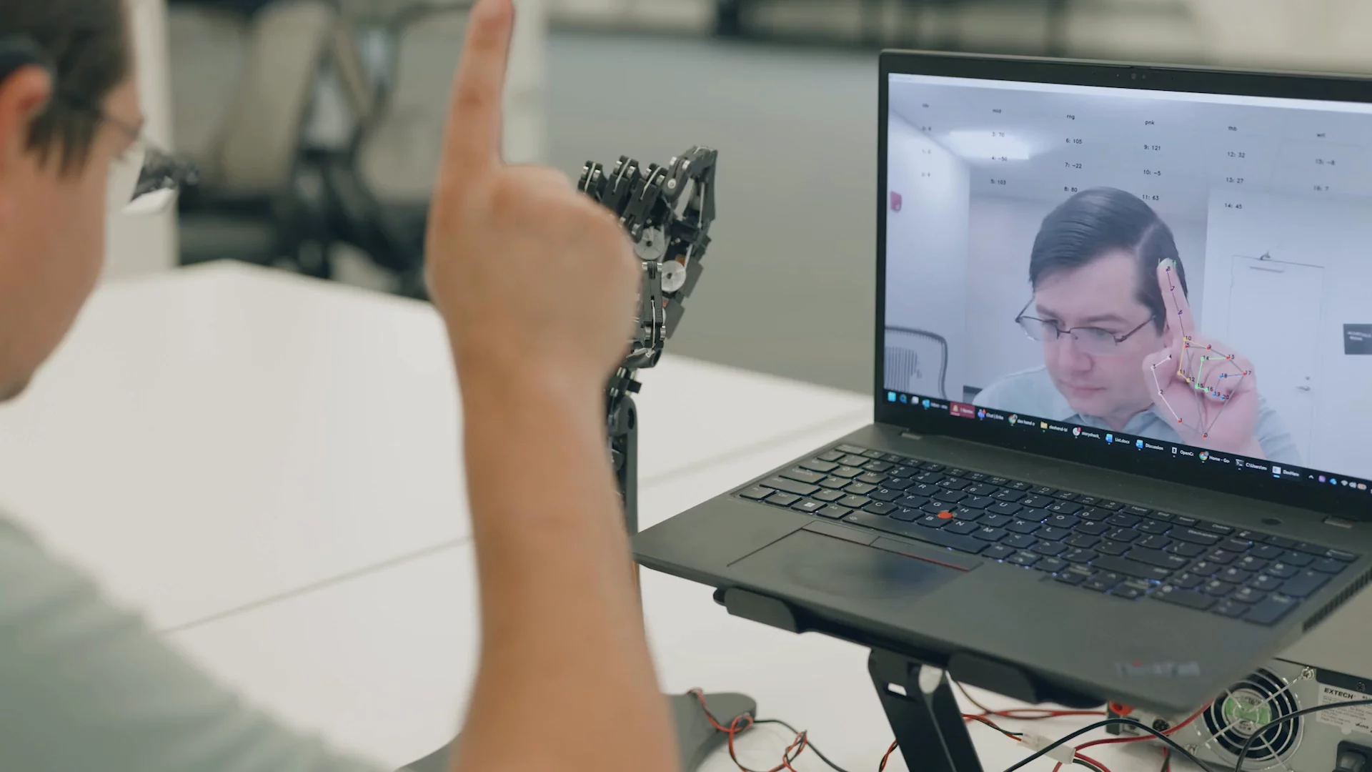 An engineer with a robotic prosthetic hand on a video call.