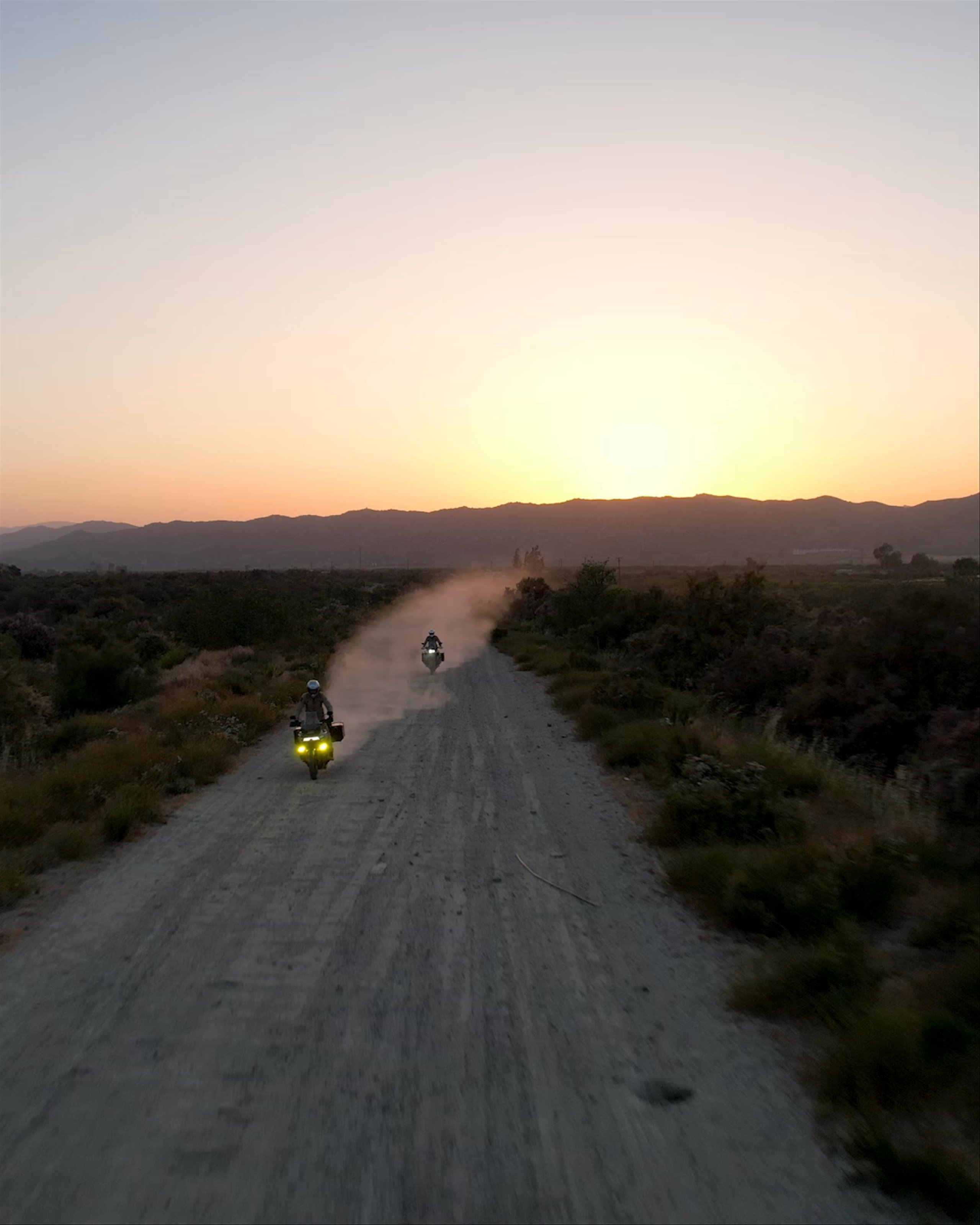 Video of motorcyclists riding down dirt road at sunset in Baja California
