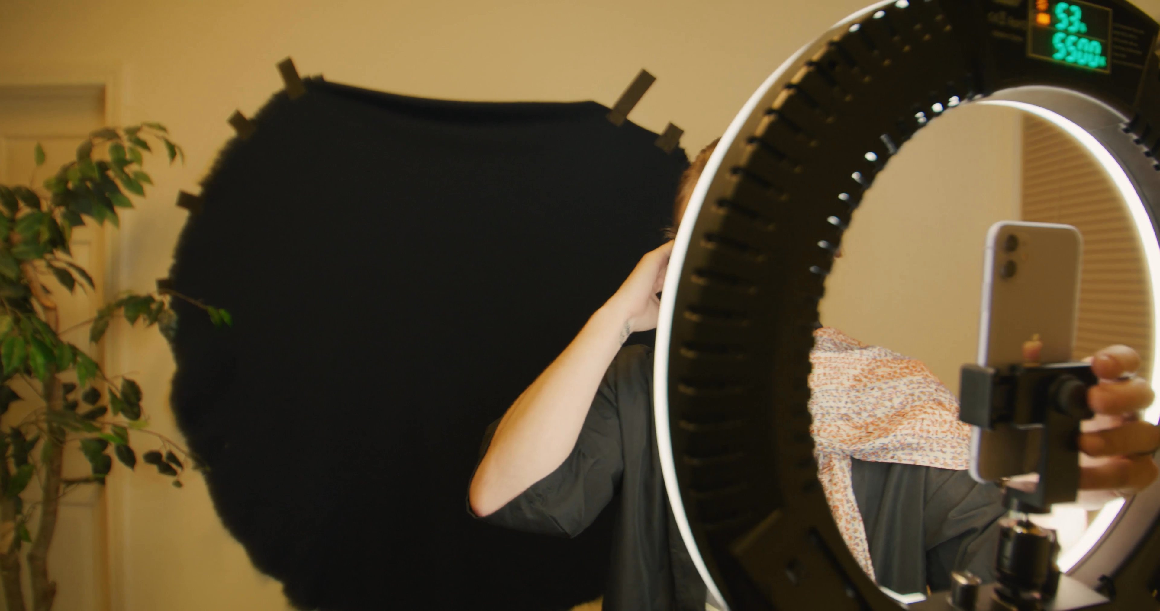 A creator prepares lighting equipment in a studio setting before collaborating with a guest for a video segment.