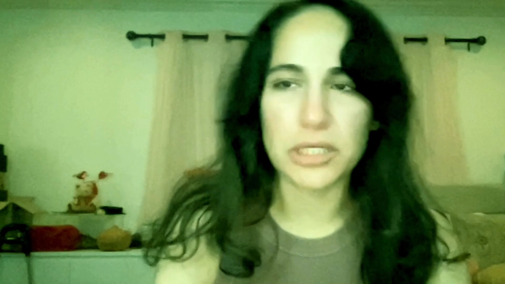 A woman shares an emotional and distressed personal narrative while recording herself in a residential setting. Her facial expressions convey sadness, vulnerability, and tears throughout the candid address.