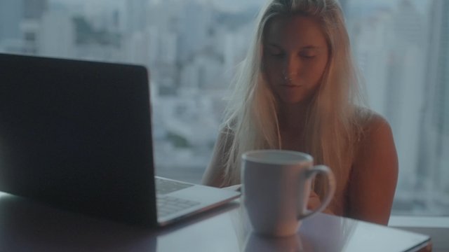 A girl sitting at a table taking a selfie