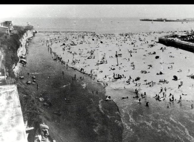 Historical archival imagery displays the Santa Cruz boardwalk and beach area, transitioning into original 1885 newspaper clippings detailing local railroad show announcements.