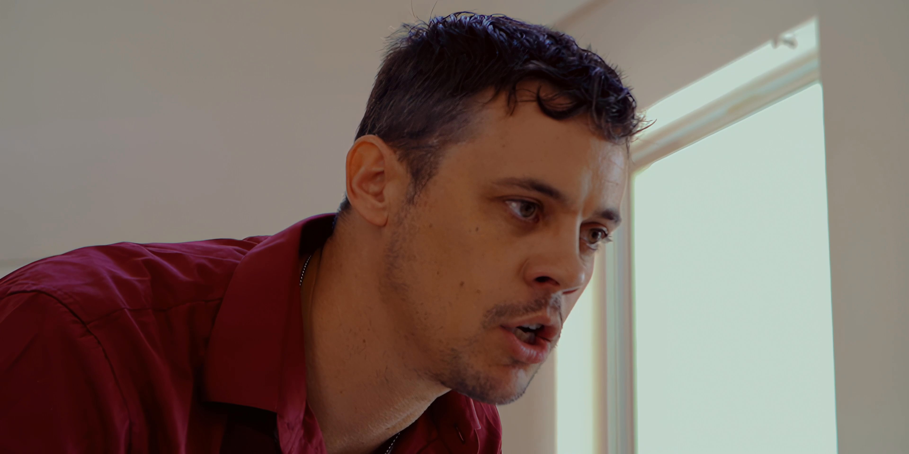 Two men engage in a heated and emotionally charged confrontation, alternating between expressions of frustration and intense focus. The scene captures the high-stakes dynamic of their verbal disagreement within a private interior space.
