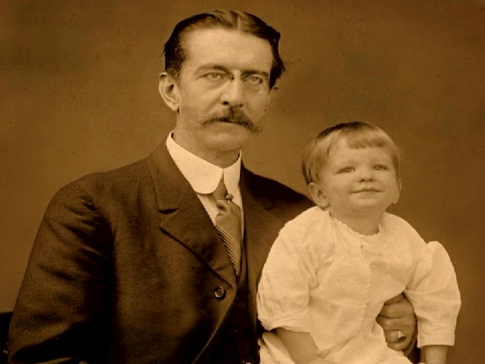 A visual progression through historical footage depicting New York Stock Exchange crowds and vintage family portraits, culminating in contemporary personal storytelling. The sequence contrasts public industrial history with intimate domestic life.