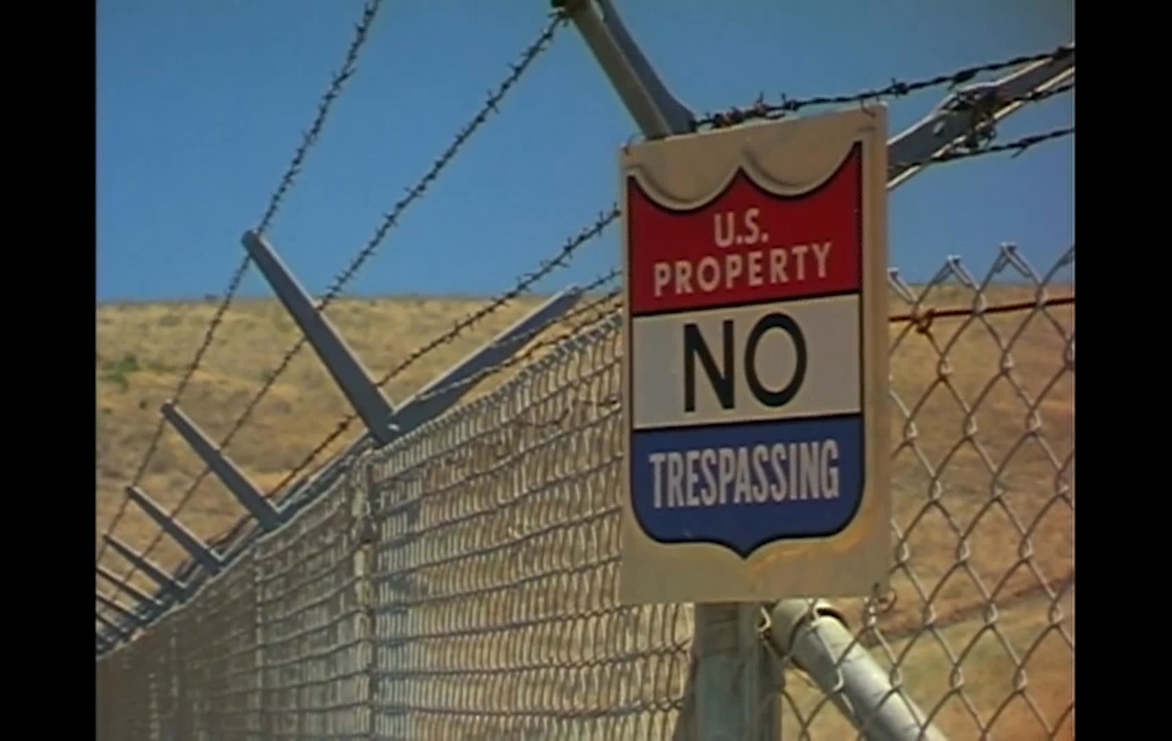 Hikers, a dirt biker, mining equipment, oil pumpjacks, and a fenced installation appear across rugged open land as a large cattle herd moves through a range. The narration discusses reducing cattle numbers to limit trampling along stream banks amid other uses of the land.