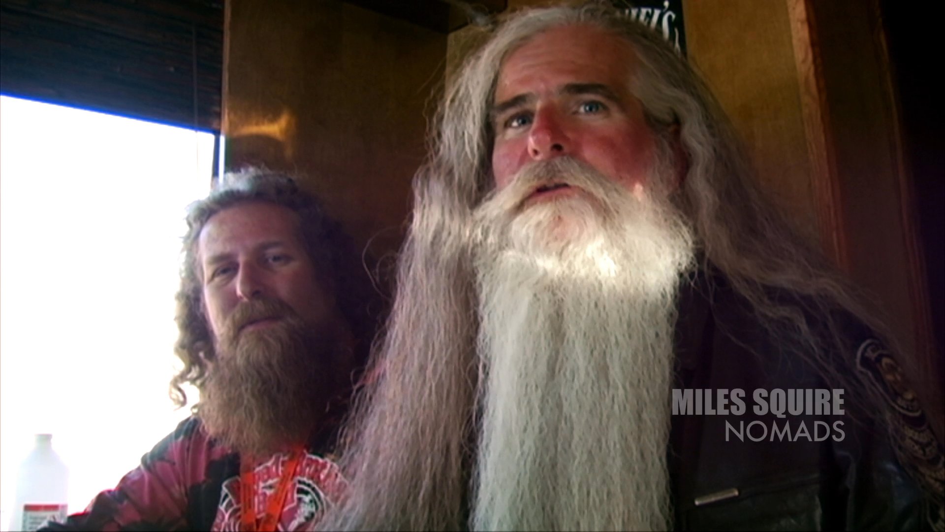 A tattooed motorcyclist shares personal experiences in a desert setting, followed by an interview with a long-bearded member of the Nomads club.