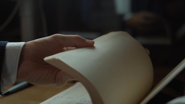 Hands turning pages in a notebook