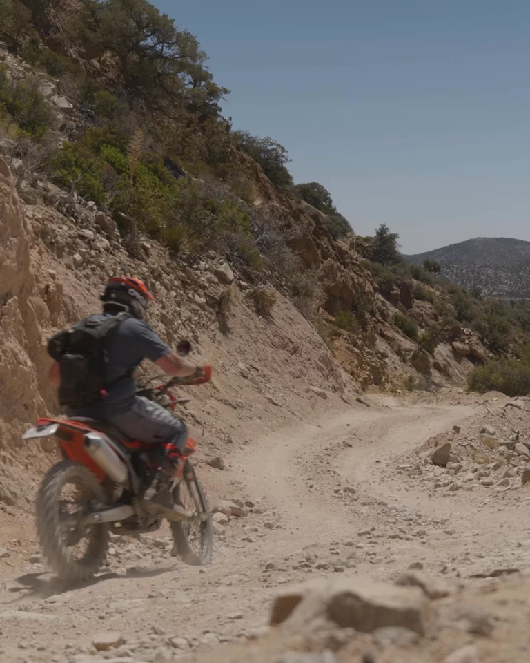 Video of motorcyclist riding on mountain path waving