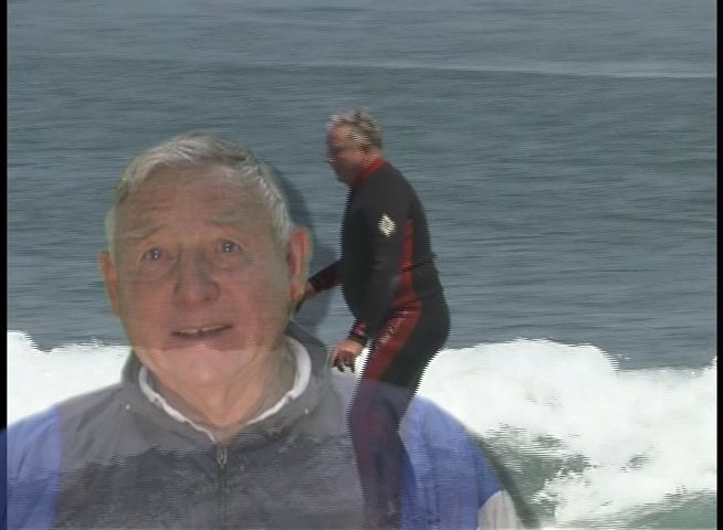 Doug Thorne provides commentary while footage of a surfer riding ocean waves plays in the background. The interview focuses on surfing technique and coastal water sports activity.