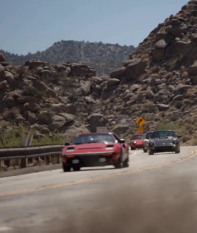 Vintage cars driving on road in the Joshua Tree