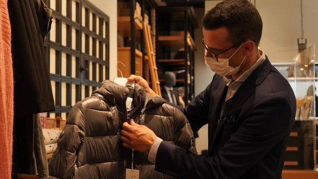 Store assistant adjusts jacket