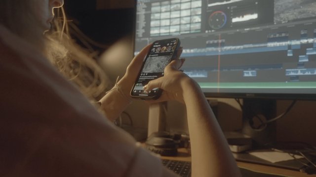 A female video editor is checking her social media