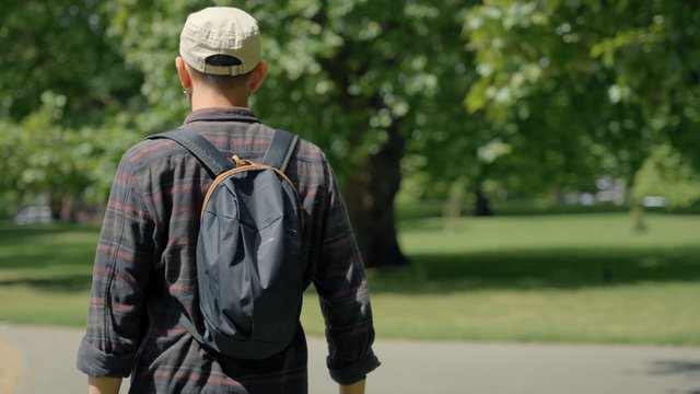 Back view of a man walking in the park