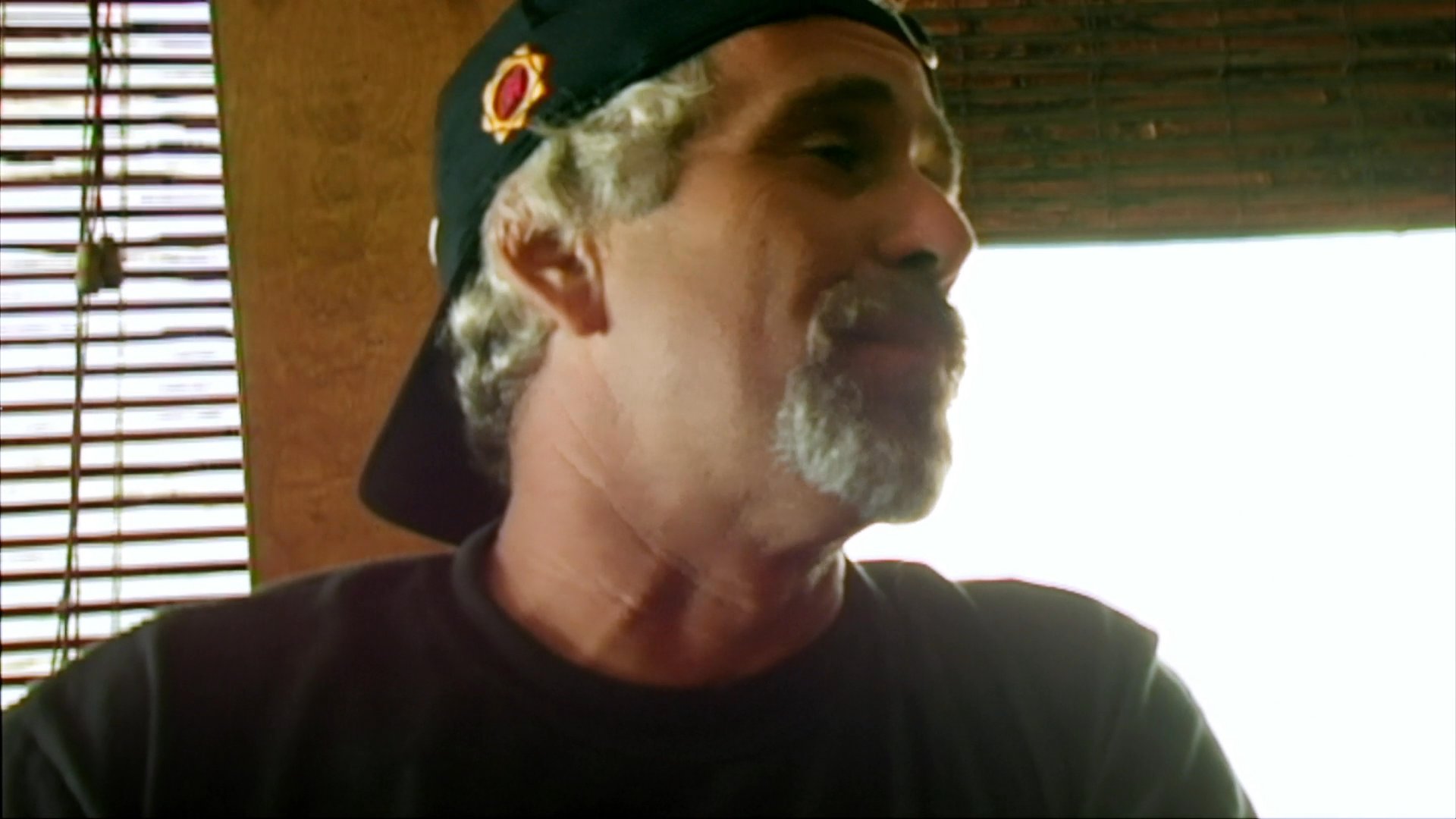 A man shares his travel experiences during an interview while driving through a vast desert landscape in an RV. The scene captures a candid, conversational perspective on the road-trip lifestyle.