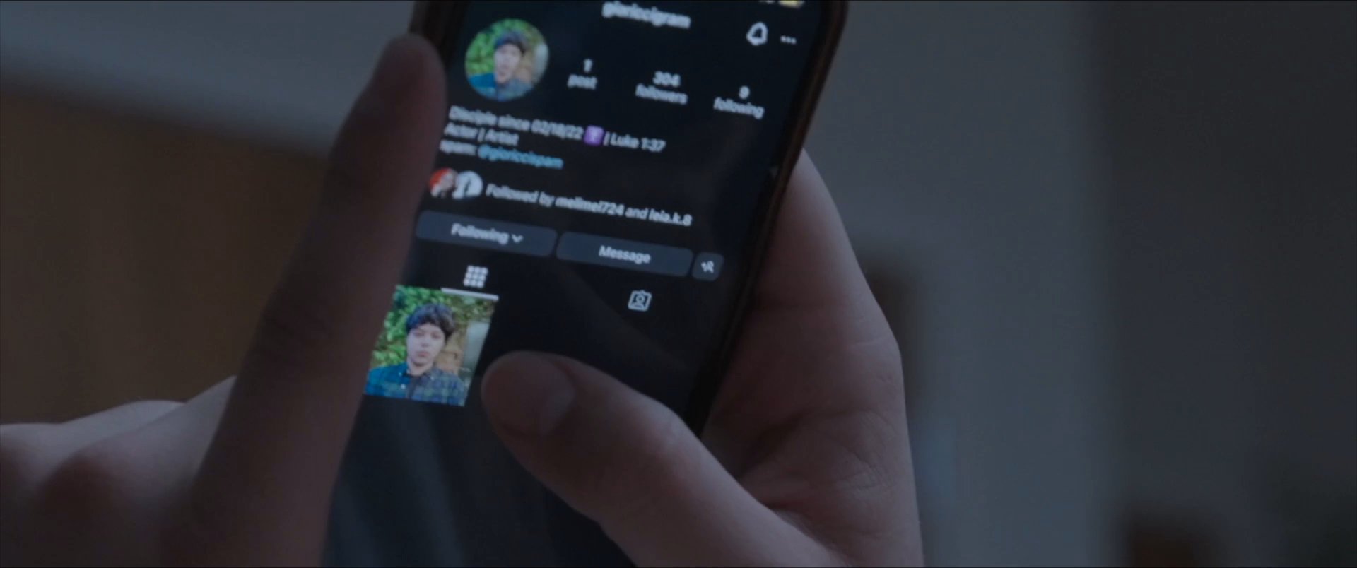 An individual reviews an Instagram profile, navigating through a collection of personal photographs and biographical details displayed on a smartphone screen.