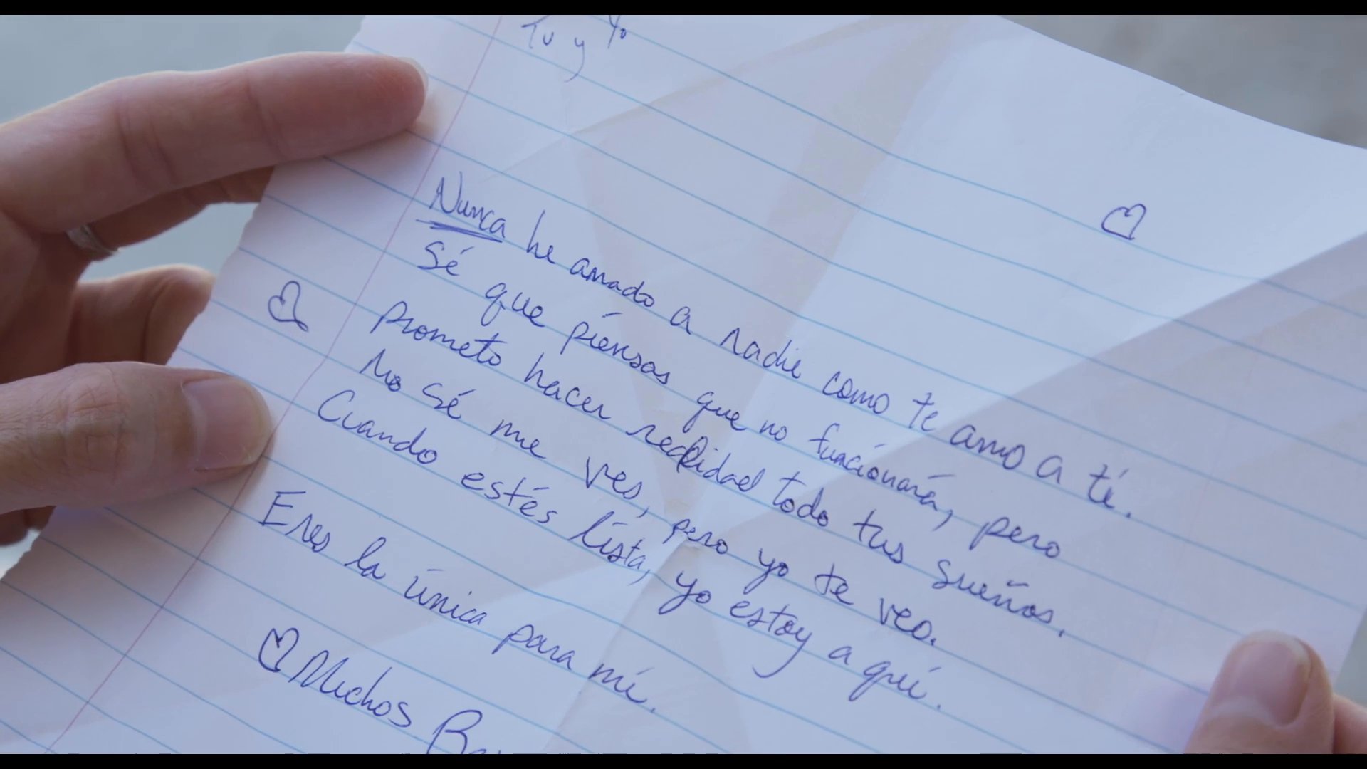 A woman sits inside a car and reads a handwritten letter expressing deep affection and promise. The scene highlights a moment of personal reflection and emotional connection.