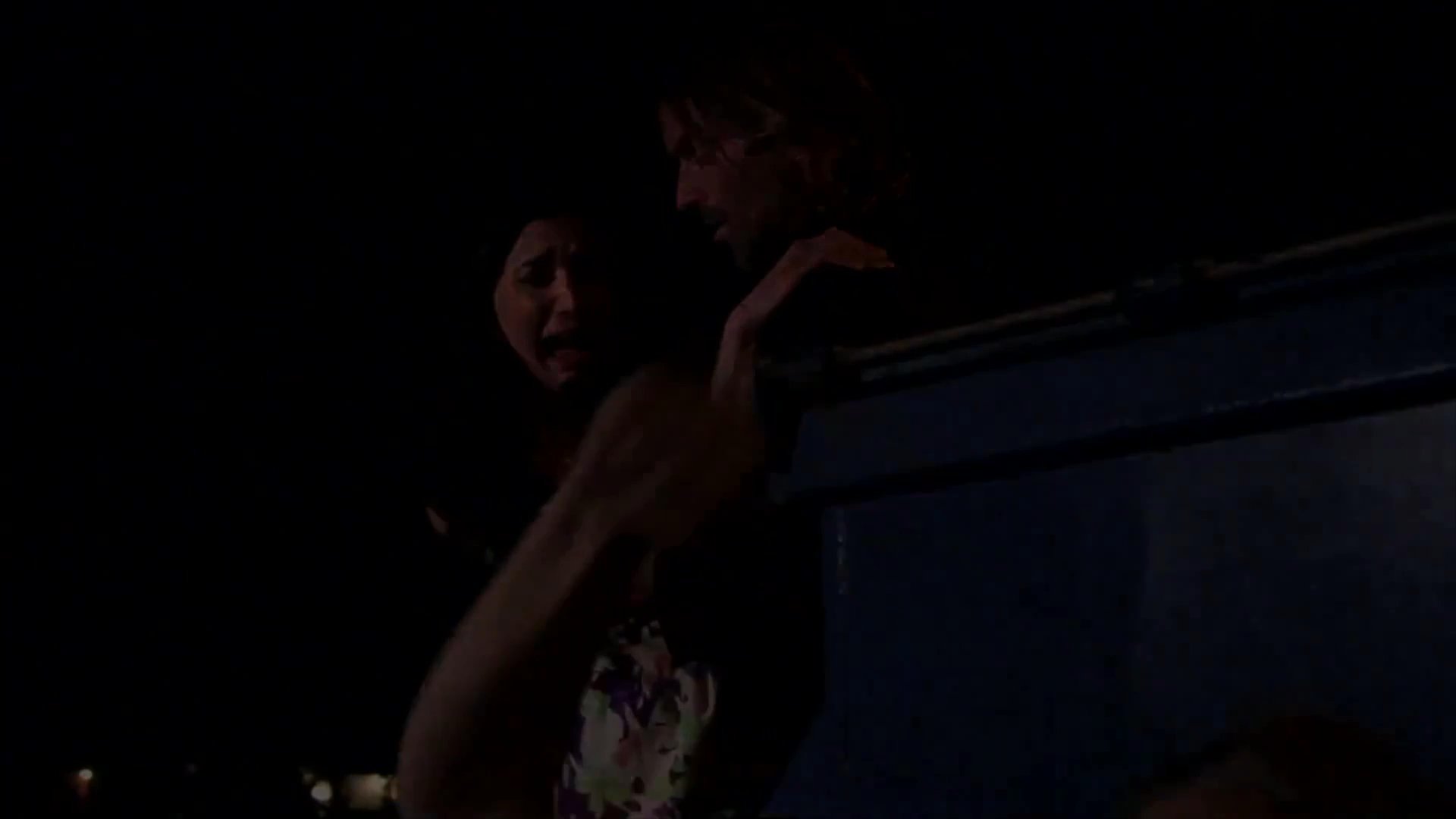 A man and a woman arrive at a dark location where they encounter a scene of distress involving another woman covered in blood. A somber investigator questions the survivors about the traumatic incident.