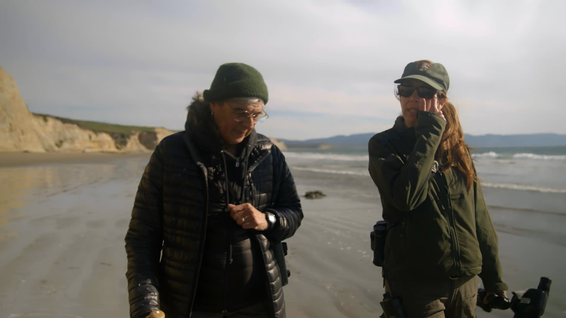 Two wildlife researchers work beside elephant seal pups on a remote beach, preparing to tag them. They share their passion for the ocean, while one reflects on mentoring her colleague.