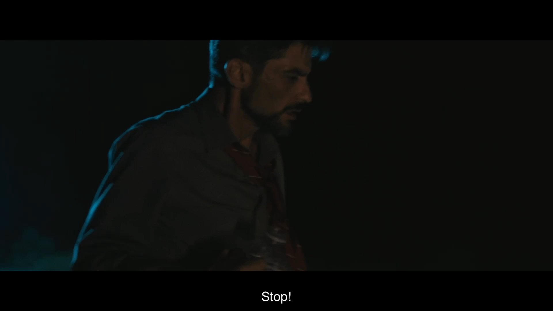 Two men experience a tense confrontation in a dark outdoor setting while struggling with limited water supplies during a long journey. The exchange escalates as one man attempts to intervene to ensure resource management.