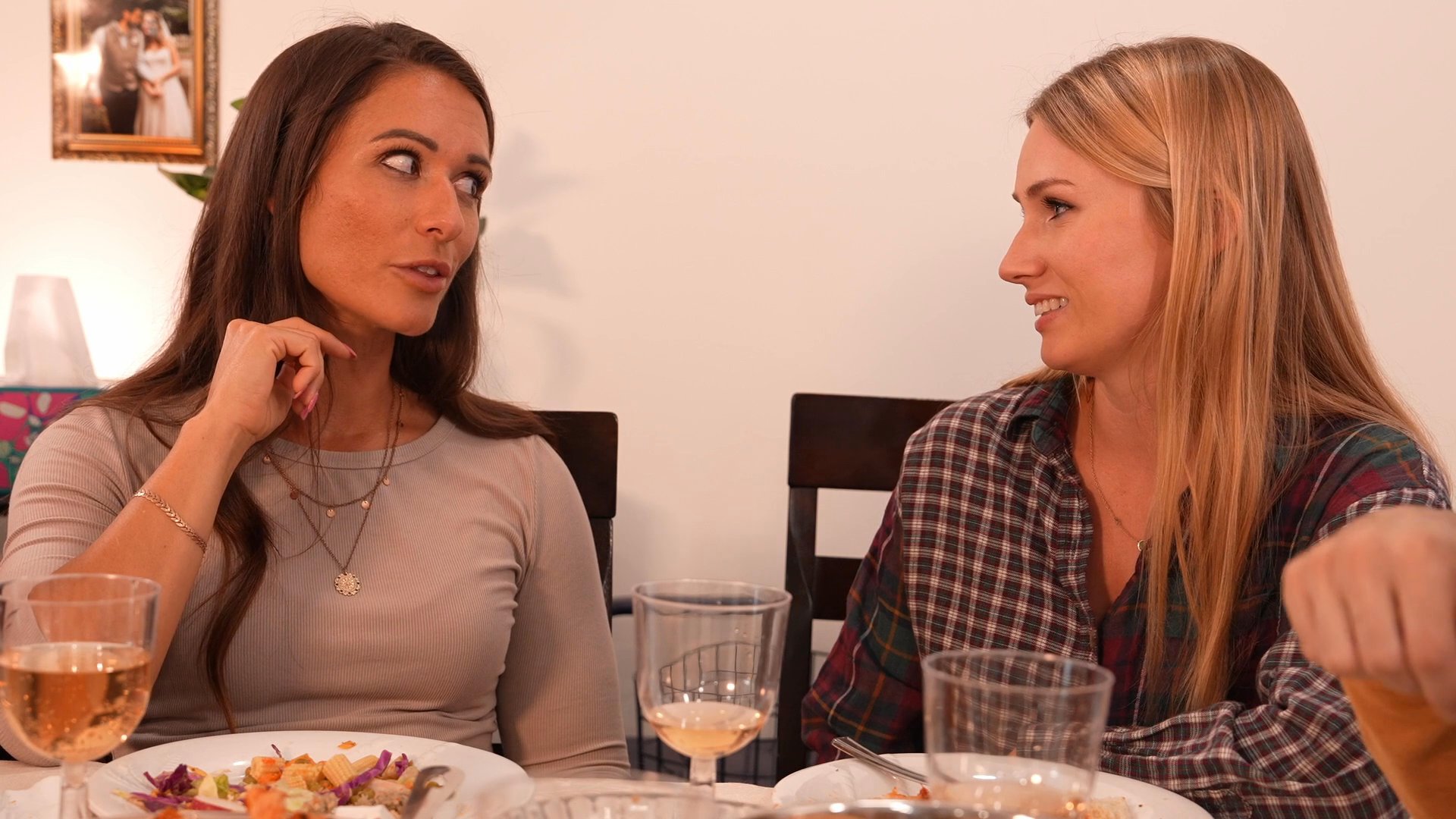 Friends participate in casual conversation and social interaction while dining together at a home gathering.