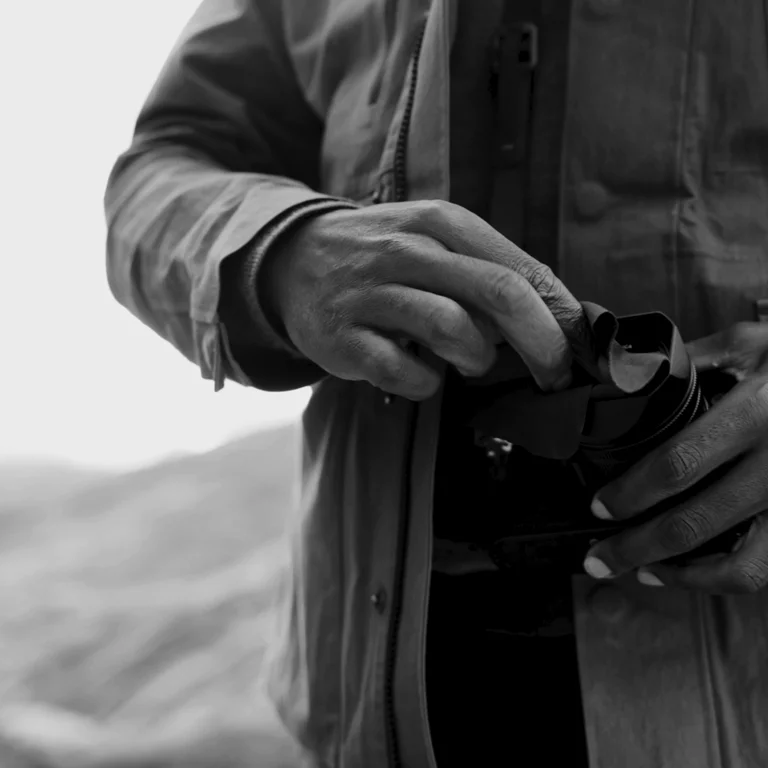 Man cleaning camera lens with cleaning cloth
