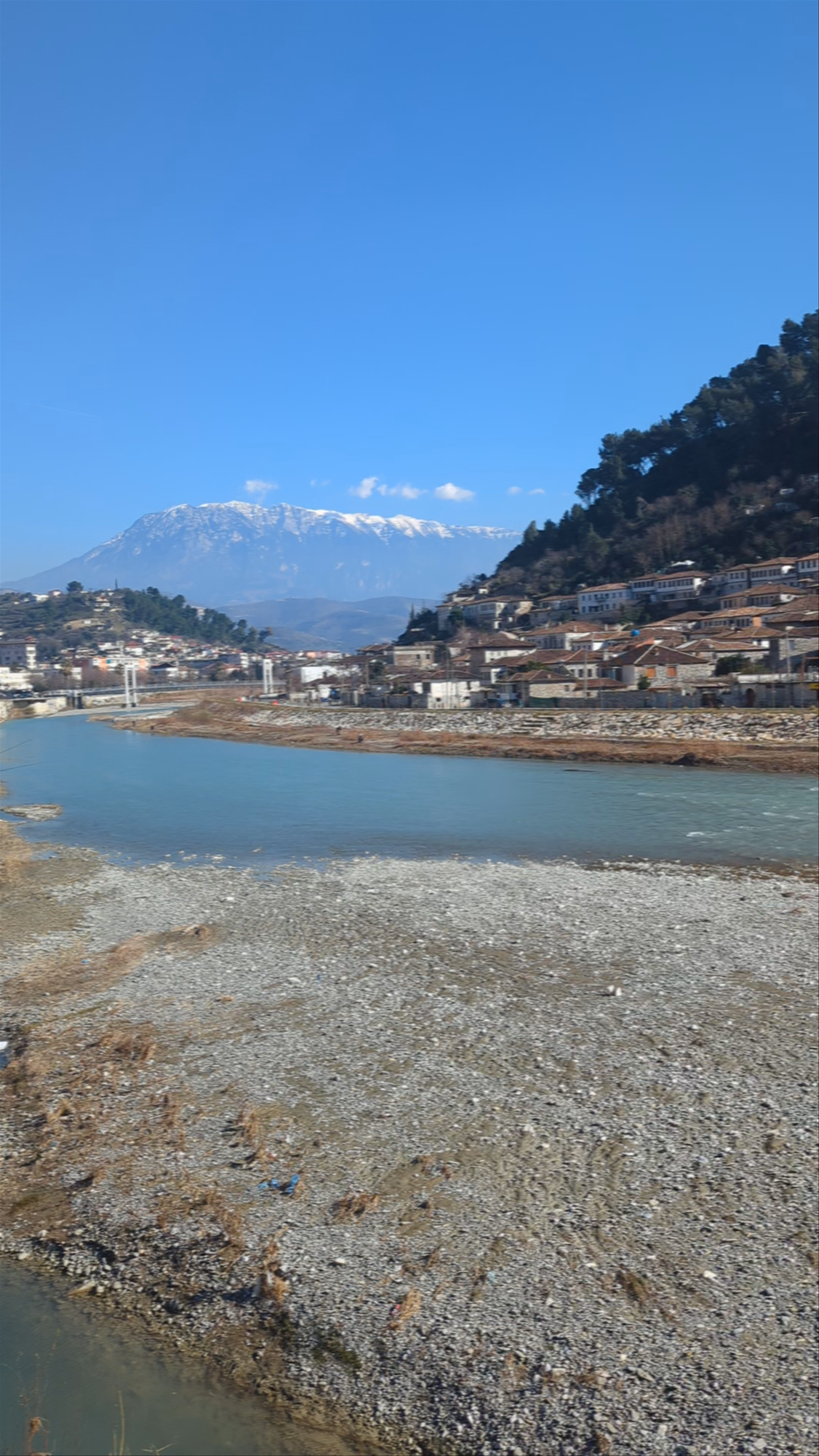 Strolling Across Gorica Bridge with Snowy Mountains in the Background – Berat, Albania