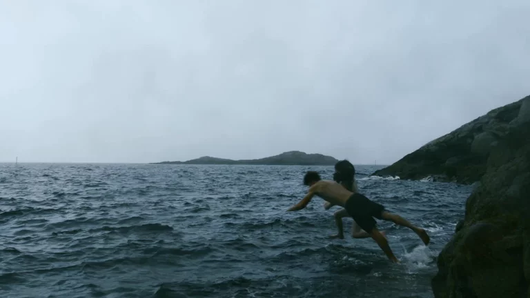 Video of man and woman diving from rocky shoreline into cold sea in Northern Norway