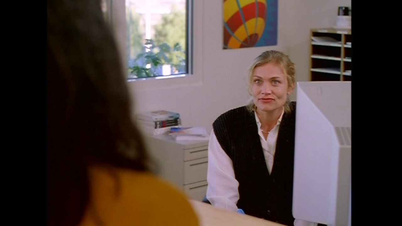 Two colleagues engage in a professional discussion within an office setting, transitioning to a view of the corporate campus grounds.