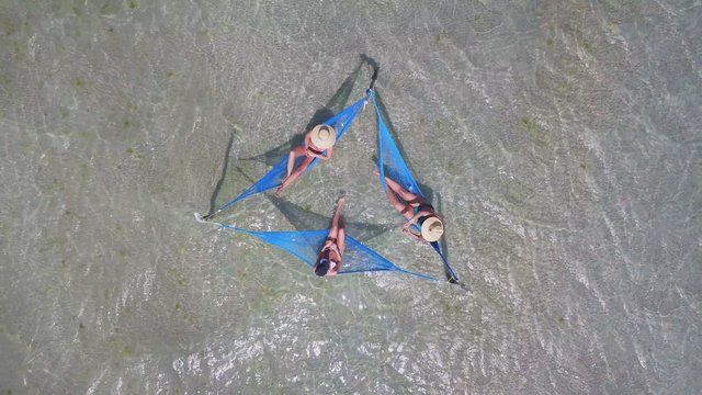Friends in hammocks in shallow water