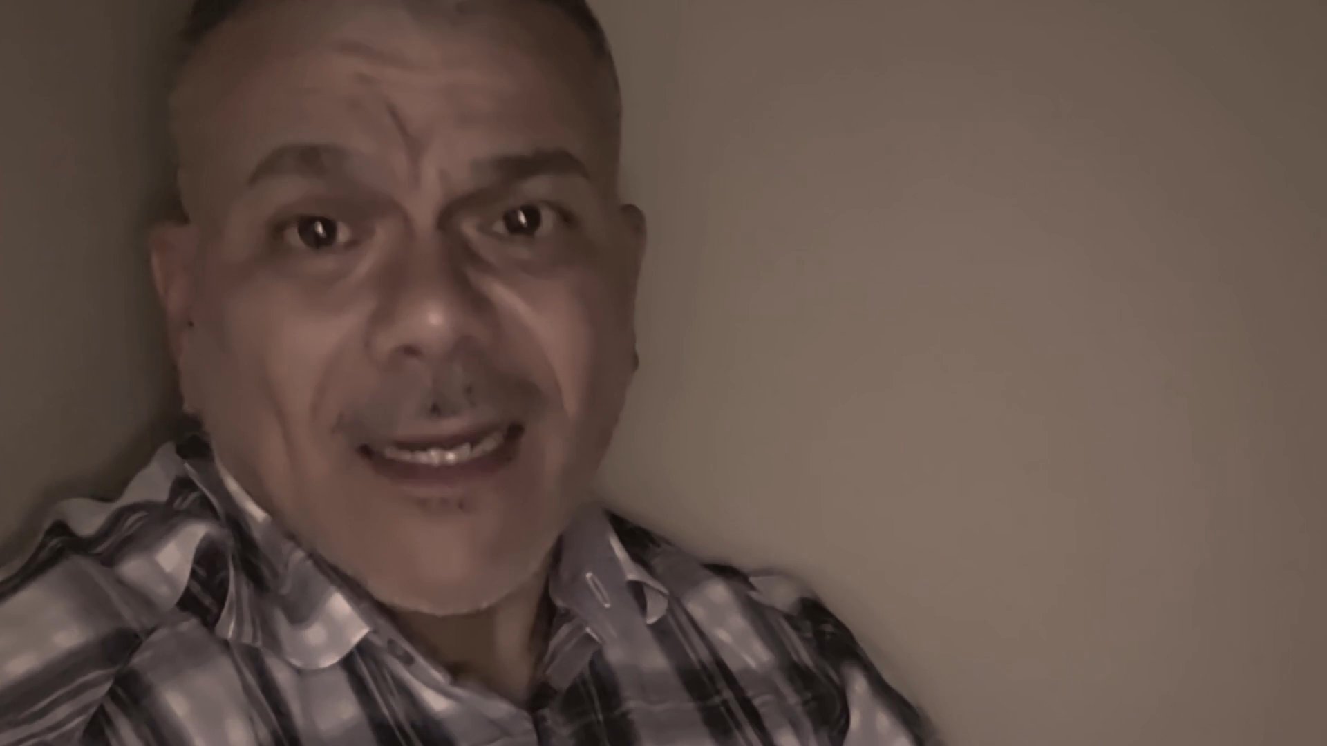 A man addresses the camera in a direct, conversational manner, sharing thoughts or a personal message with focused intensity.