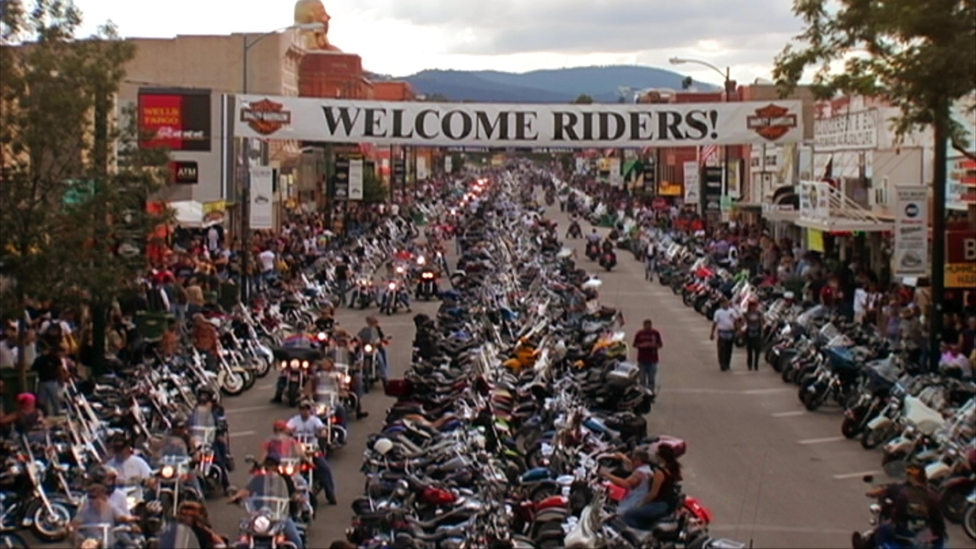 The Sturgis Motorcycle Rally draws massive crowds as thousands of motorcycles line the main street of Sturgis, South Dakota. Interspersed with these scenes of the rally, an acoustic musician performs for an audience.