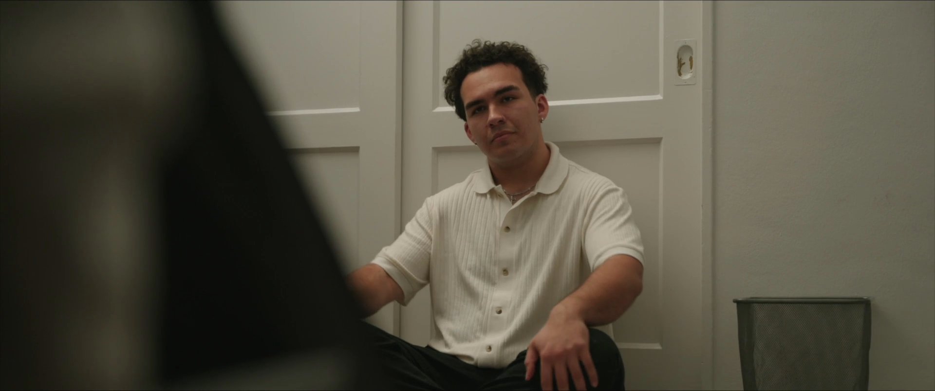 Two men engage in a thoughtful, centered conversation while sitting in an indoor setting. The exchange shifts from focused contemplation to active verbal communication.
