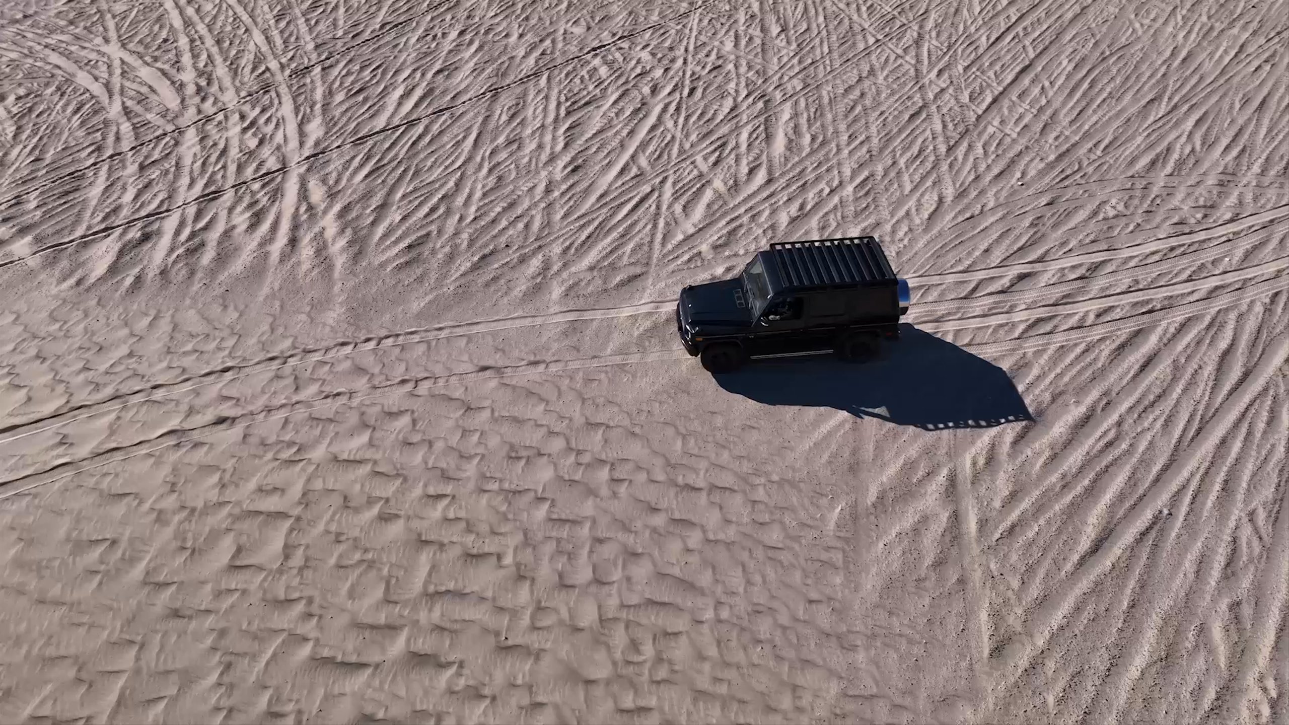 Video montage of man and woman wearing AETHER sunglasses in California sand dunes