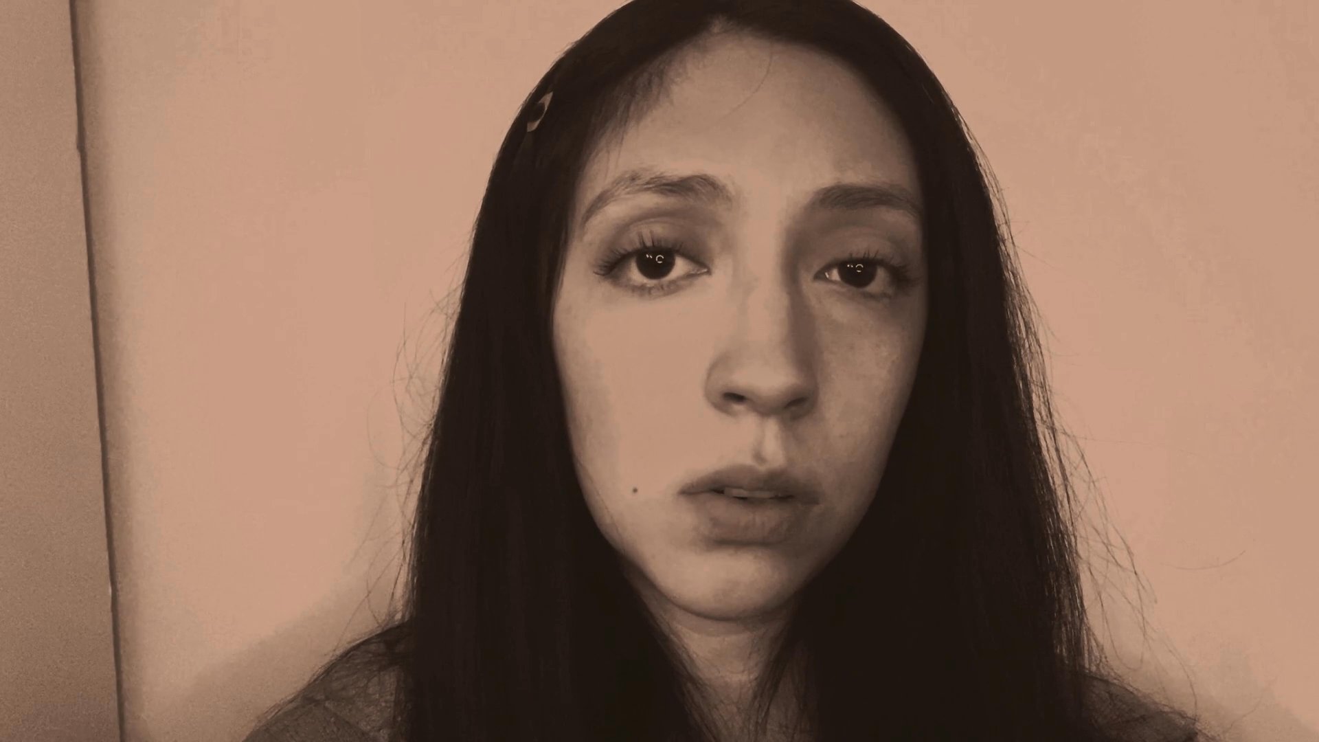 A woman delivers a monologue with varied, expressive facial movements and shifting gaze. Her changing expressions convey a narrative or emotional story directly to the viewer.