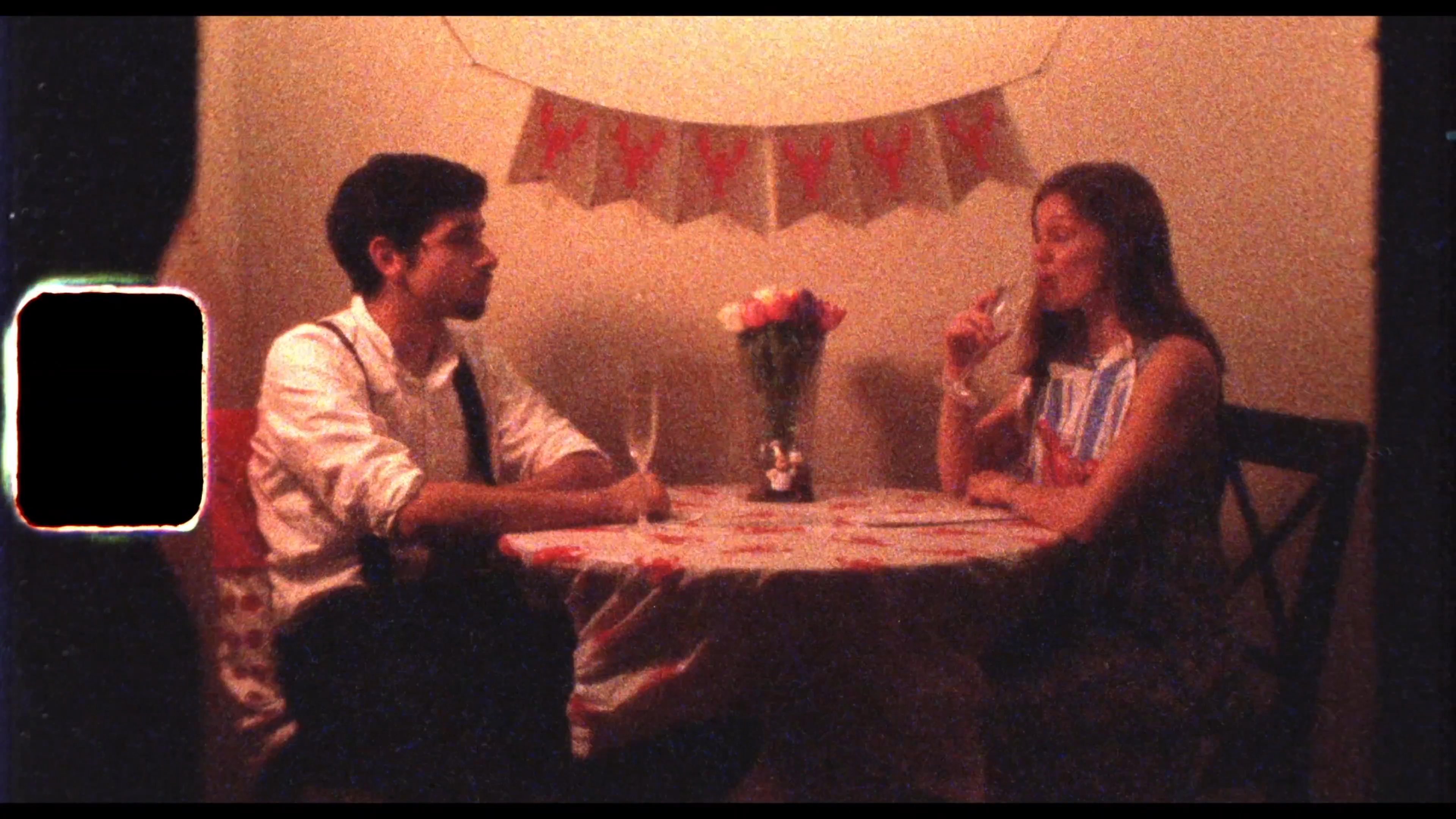 A chef interacts with a lobster in an aquarium before transitioning to a couple having a romantic dinner, followed by the chef humorously wearing a lobster around his neck.