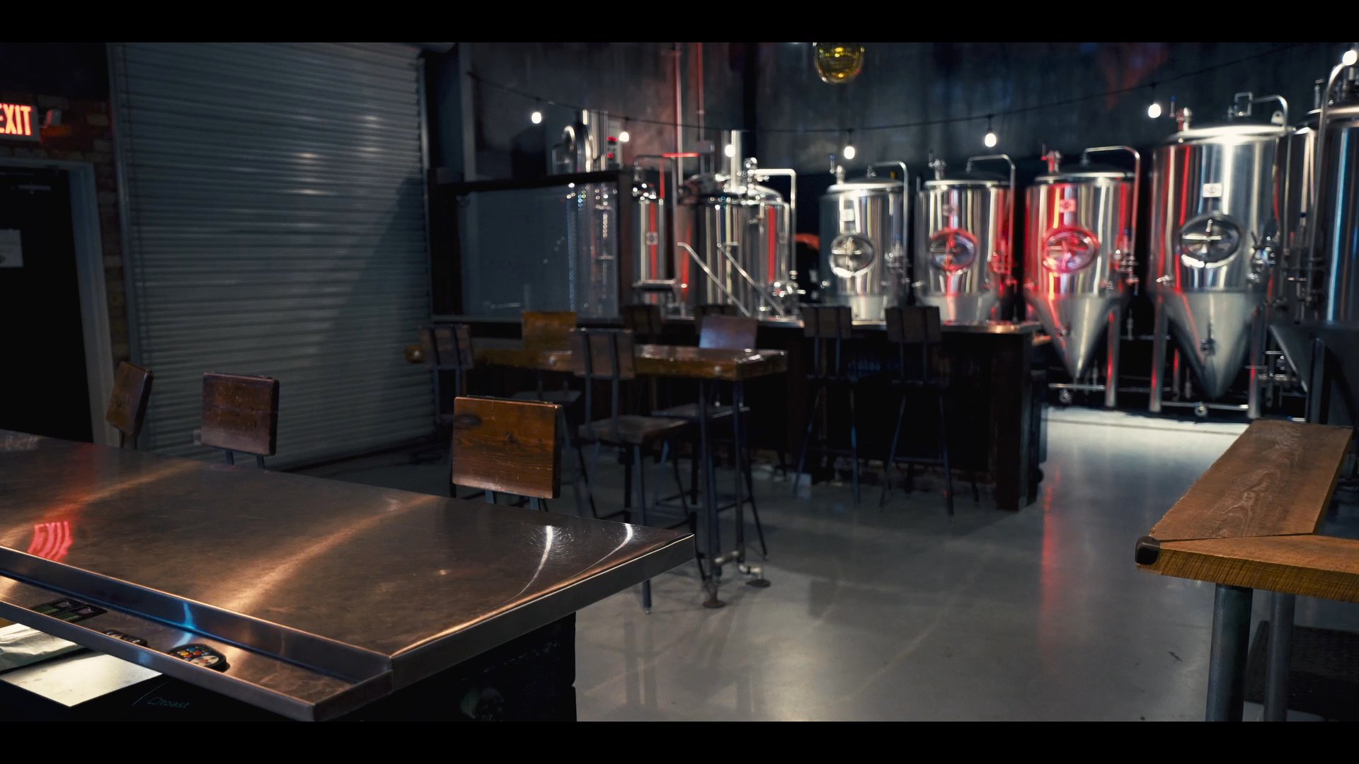 Two men engage in a conversation before moving to a modern bar setting, where they continue their interaction over drinks.