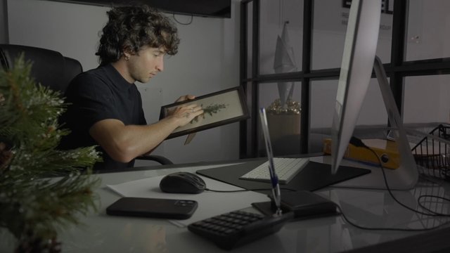 A guy wiping dust off of a Christmas frame