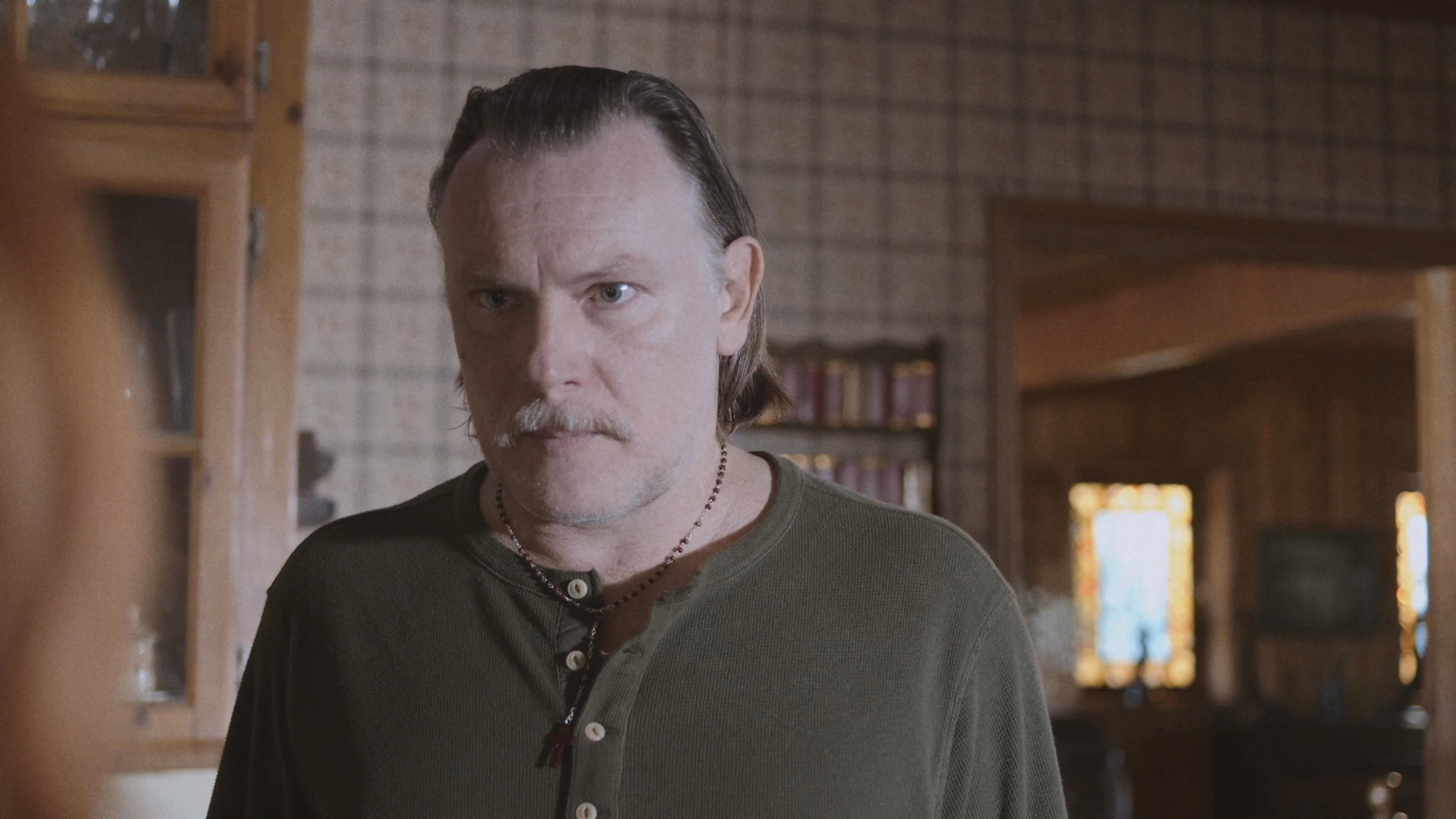 A man and a woman engage in a tense, emotionally charged conversation within a kitchen setting. The interaction shifts from personal dialogue to domestic activity as eggs are prepared in a bowl.
