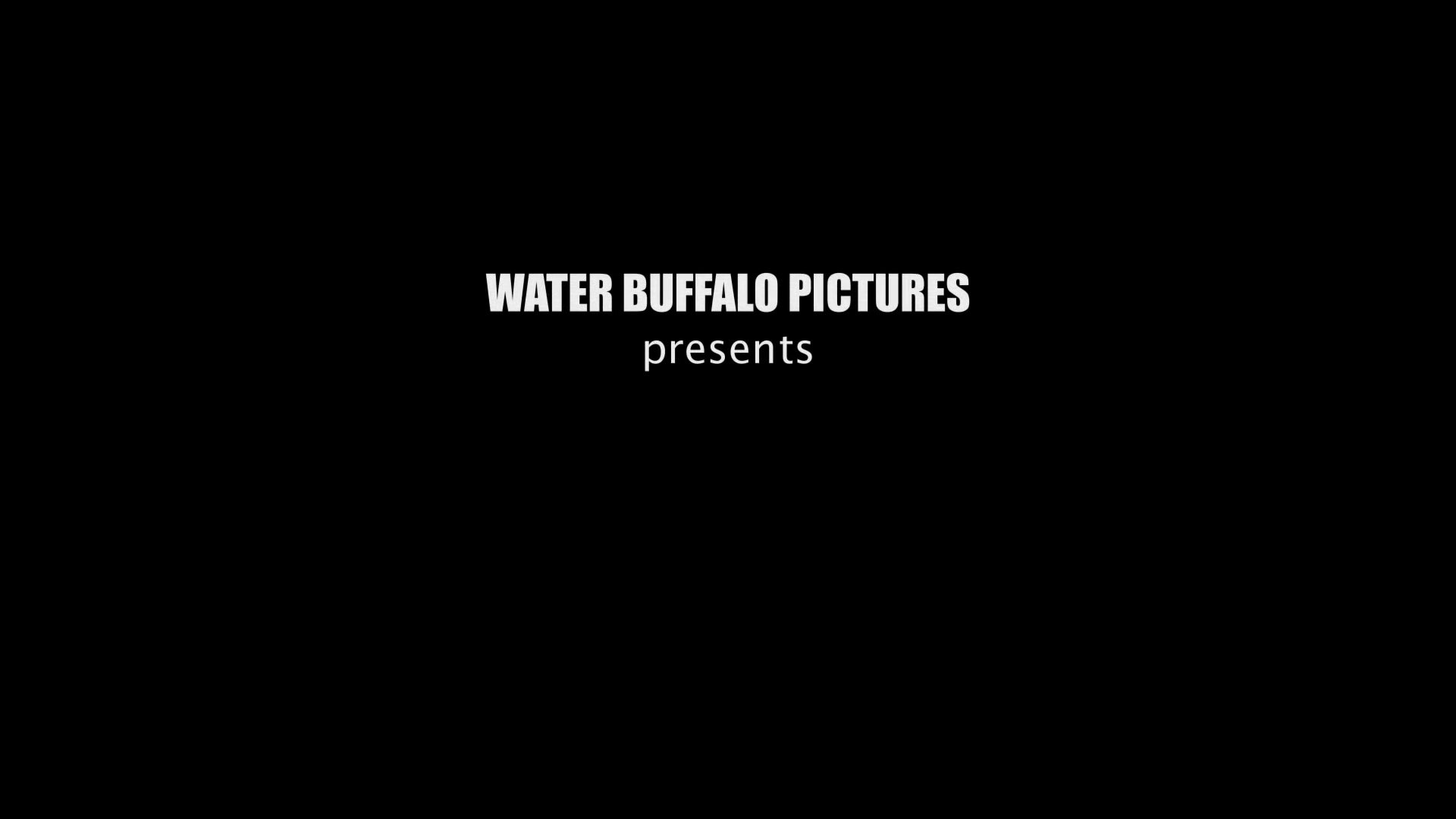 The Water Buffalo Pictures production logo appears over a static, vintage-style film shot of an outdoor plaza featuring a central fountain and pedestrians.