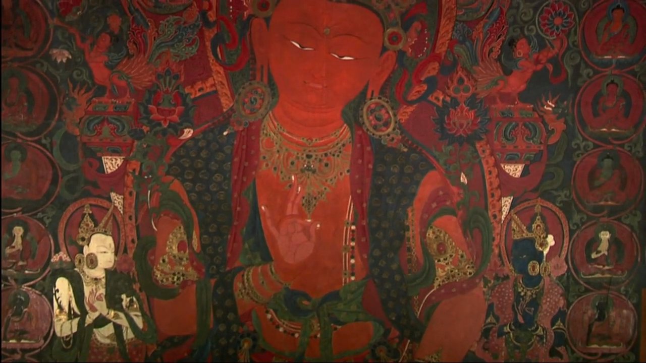 Khempo Kungo Tenzing, abbot of Choedhe Monastery, speaks about traditional religious iconography, transitioning into detailed close-ups of an intricate, red-hued thangka painting.