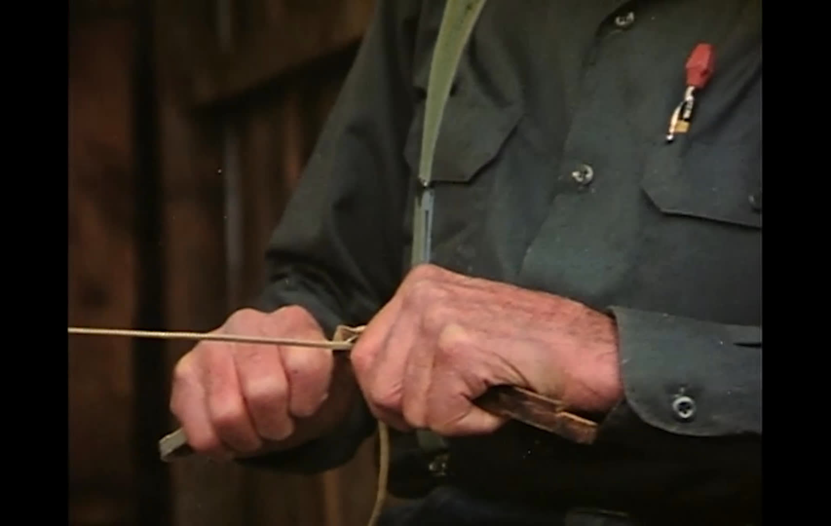 A cowboy in a dark hat works a thin line between his hands beside a rustic wooden structure. The accompanying lyrics evoke a canyon ride at sunset, blooming plants, sagebrush, and granite spires.