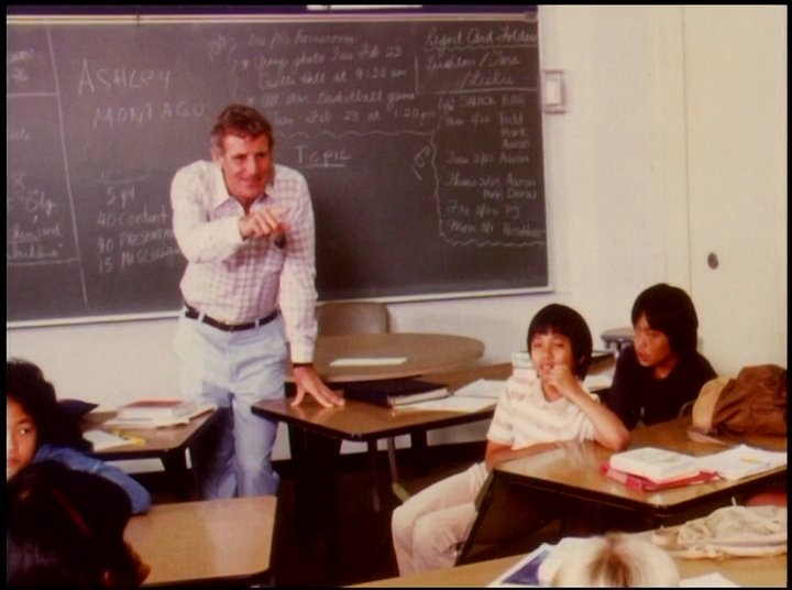 A transition between action-oriented surfing footage and a classroom setting where an instructor discusses surfing-related topics with students.