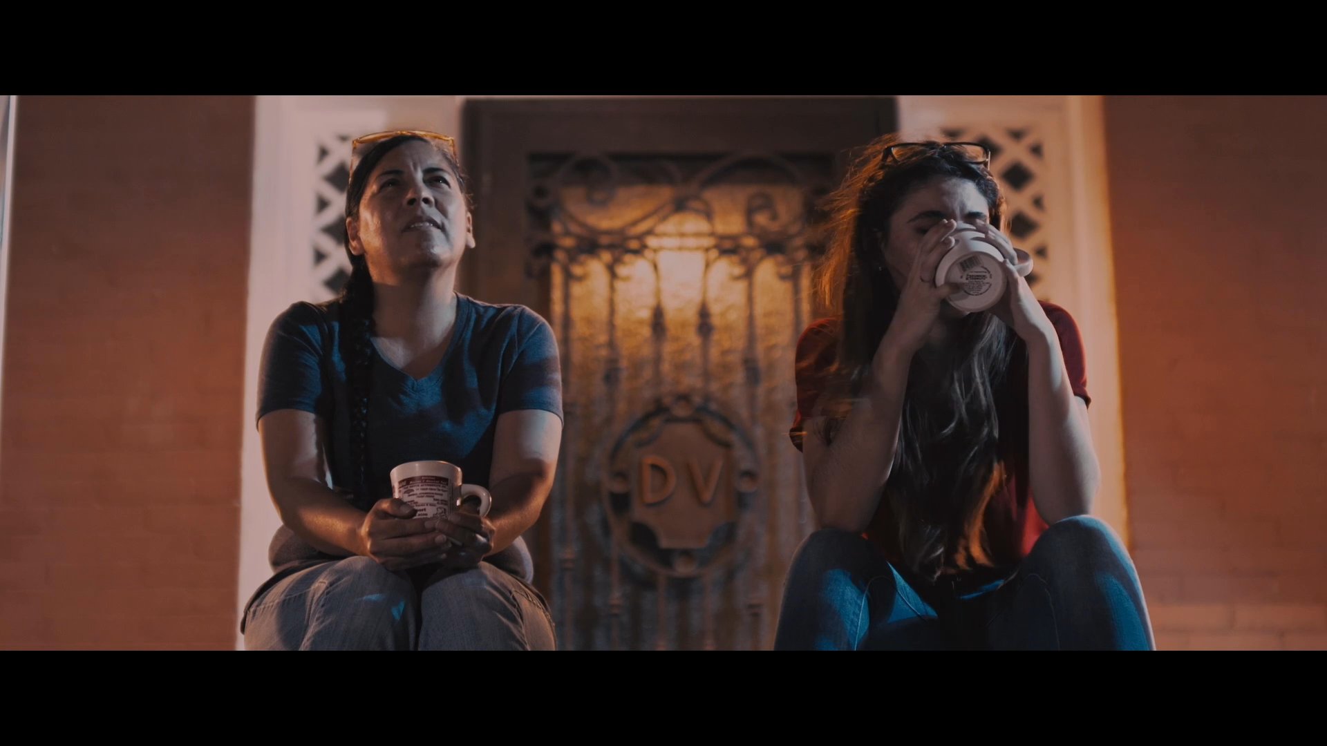 A mother and daughter engage in a candid conversation about the daughter's partner while sitting together outdoors. The mother expresses curiosity and a desire to meet him, leading to a lighthearted and intimate exchange.
