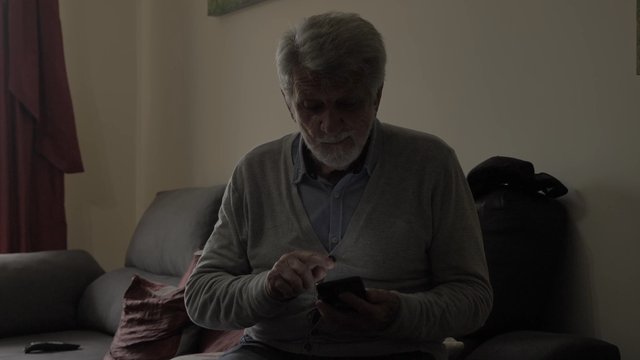Old man showing his phone to someone