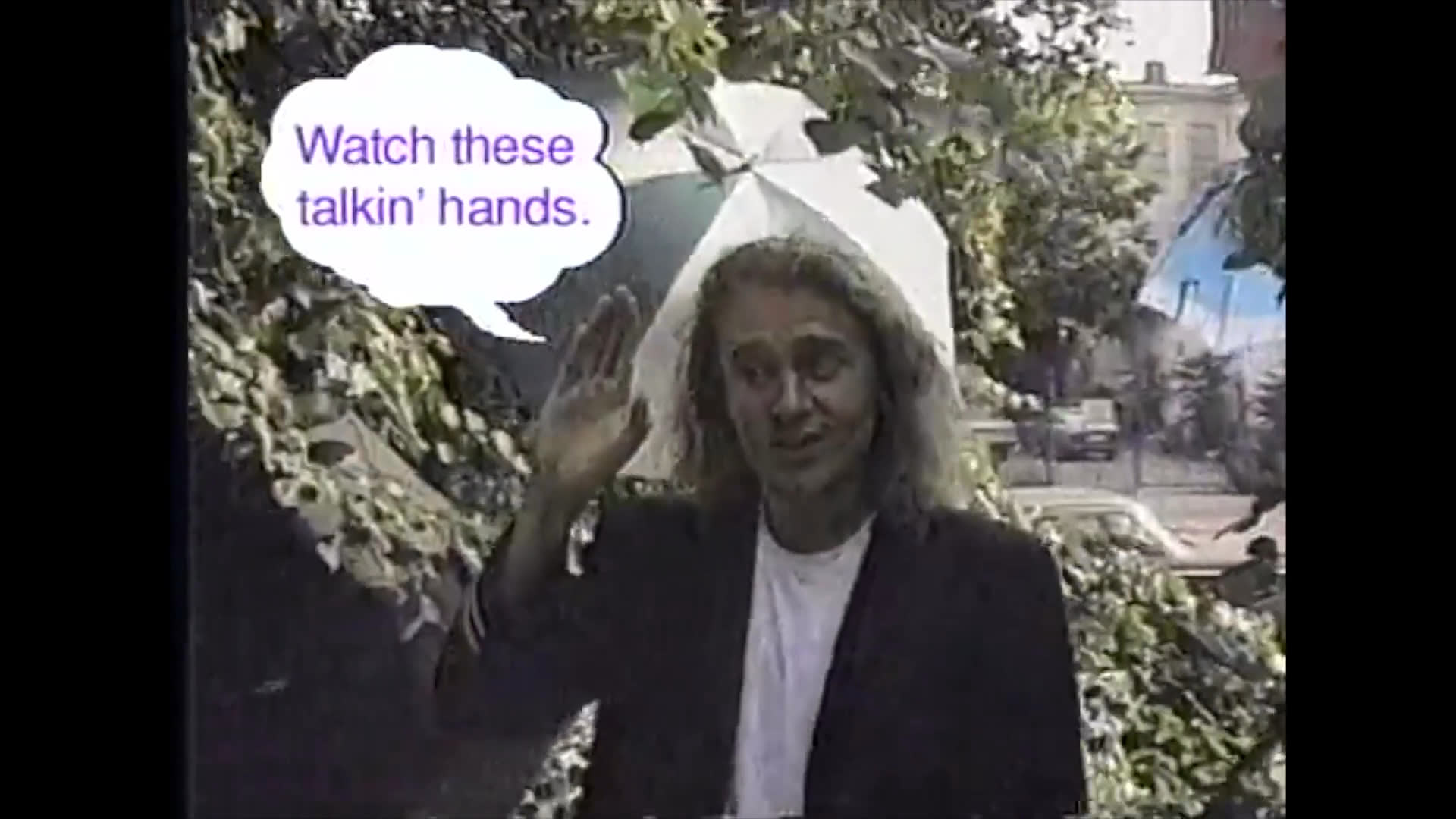 An instructor demonstrates various sign language gestures in an outdoor setting, providing visual instruction for new signs.