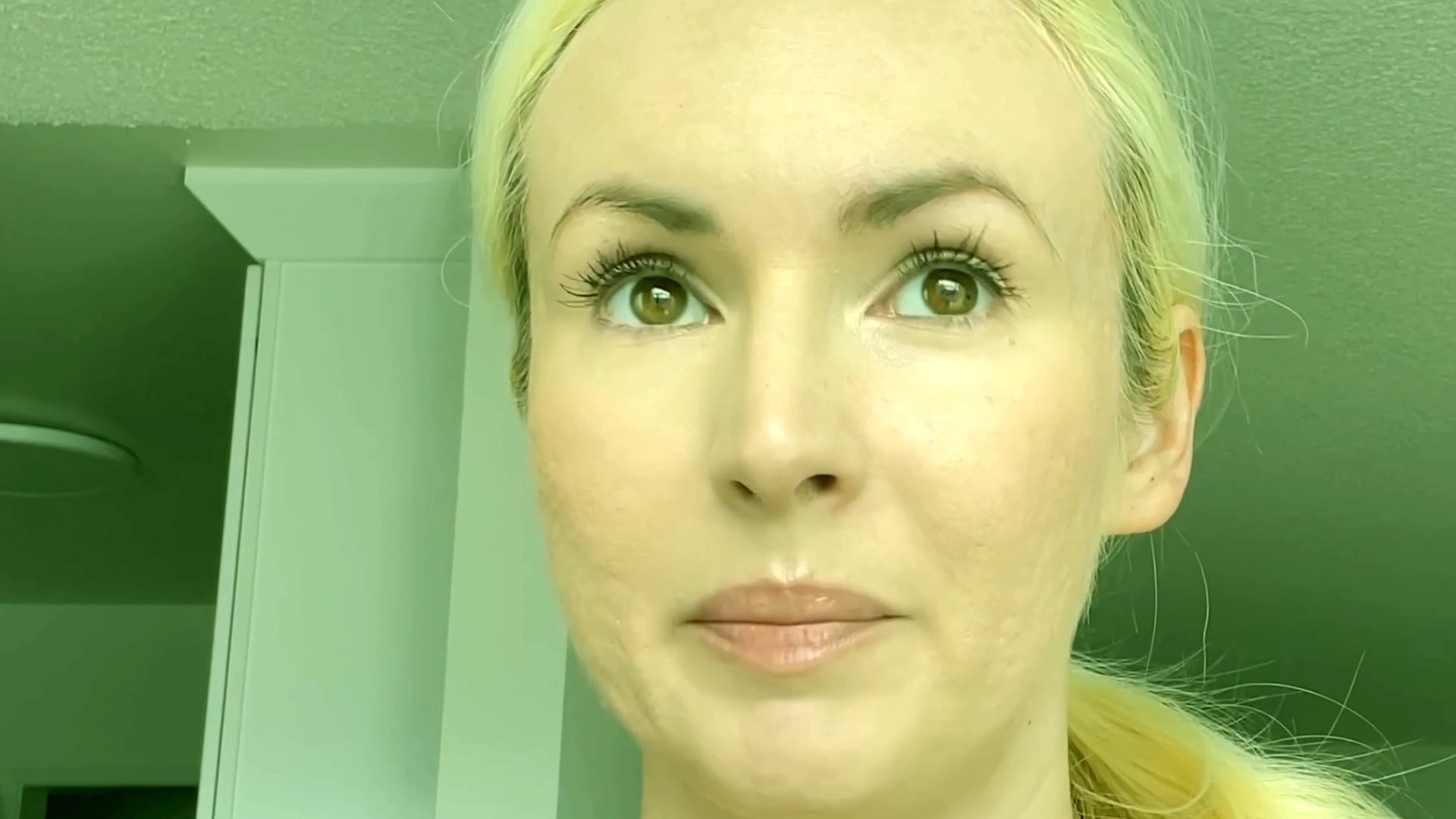A blonde woman speaks directly to the camera with varied facial expressions, conveying a conversational tone in a brightly lit setting.
